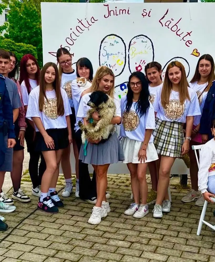 Voluntarii asociației în tricouri Inimi și Lăbuțe, cu un cățel și o pisică salvați